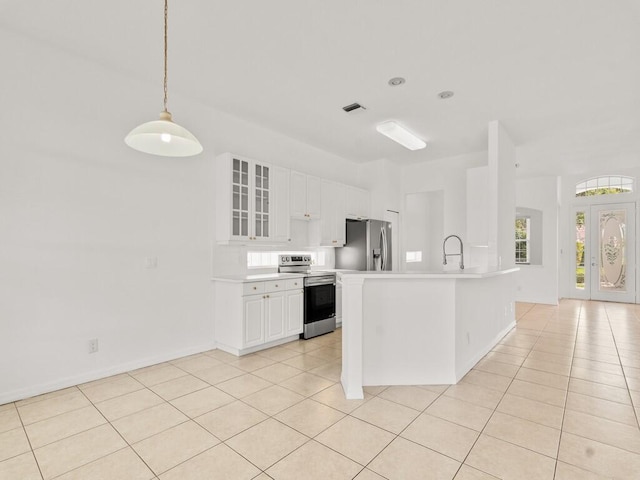 kitchen featuring appliances with stainless steel finishes, light countertops, light tile patterned floors, glass insert cabinets, and white cabinets