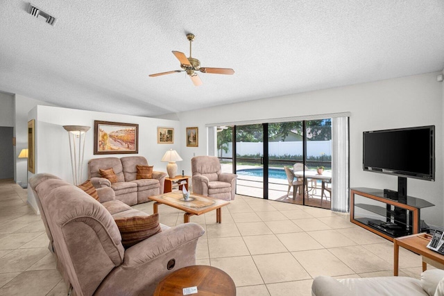 living area featuring light tile patterned floors, a ceiling fan, and a textured ceiling