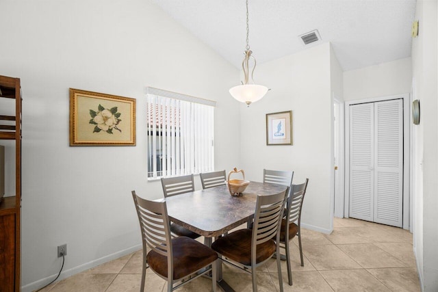 dining room featuring lofted ceiling, light tile patterned floors, and baseboards