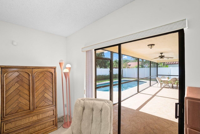 doorway with carpet, a textured ceiling, ceiling fan, and lofted ceiling