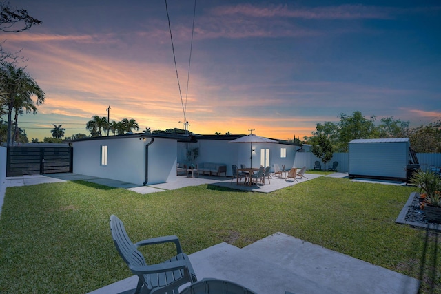 11290 SW 48th St, Miami, FL 33165 - back of house at dusk with a patio, a storage unit, an outdoor structure, and stucco siding