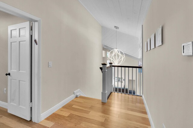 6851 Giralda Cir, Boca Raton, FL 33433 - corridor with light wood-style flooring, an upstairs landing, a chandelier, and baseboards