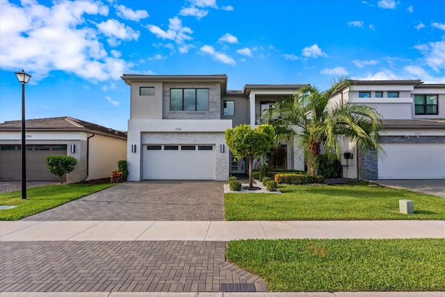 17516 Rainstream Rd, Boca Raton, FL 33496 - view of front of property with decorative driveway, stucco siding, a front yard, and a garage