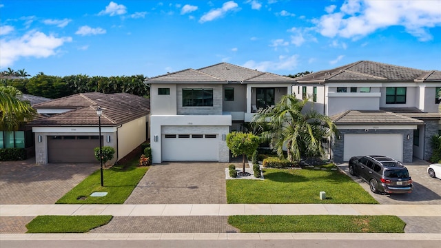 17516 Rainstream Rd, Boca Raton, FL 33496 - view of front of property with stucco siding, a front lawn, driveway, a tile roof, and a garage