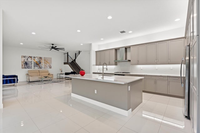 17516 Rainstream Rd, Boca Raton, FL 33496 - kitchen featuring wall chimney range hood, gray cabinetry, backsplash, open floor plan, and ceiling fan