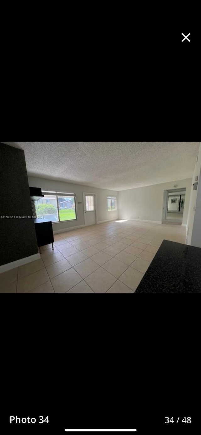 307 Pine Ridge Cir Unit C1, Greenacres, FL 33463 - corridor featuring light tile patterned flooring and a textured ceiling