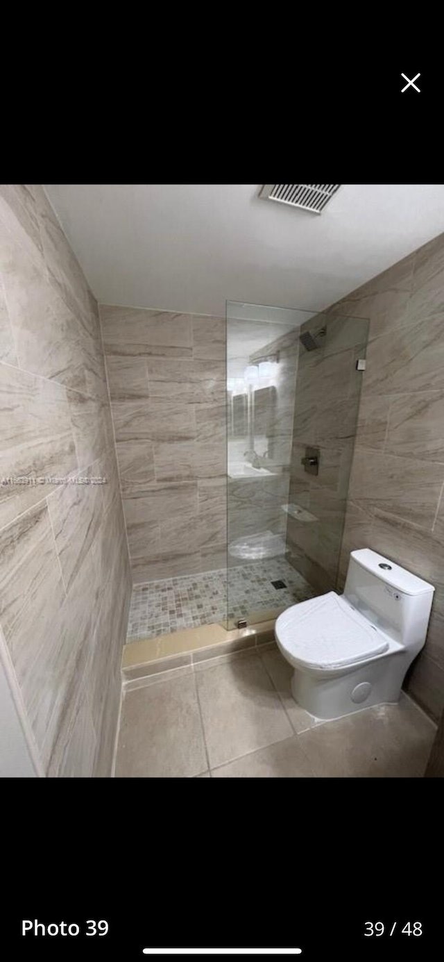 307 Pine Ridge Cir Unit C1, Greenacres, FL 33463 - full bath with toilet, a walk in shower, tile patterned flooring, and tile walls