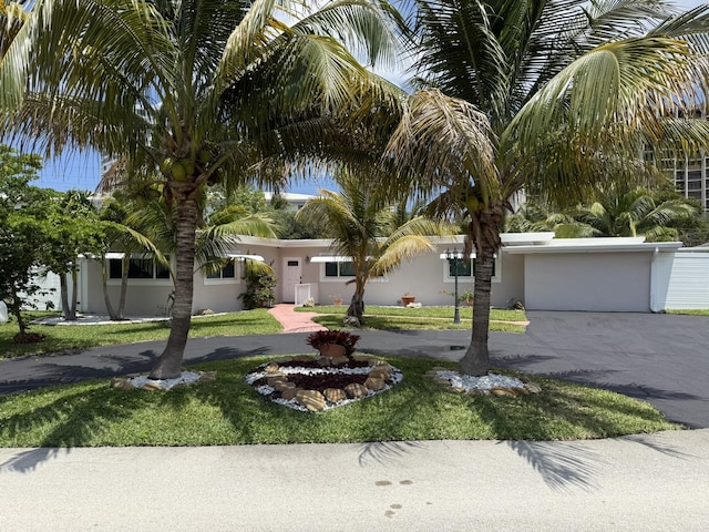 1760 Bel Air Ave, Lauderdale By The Sea, FL 33062 - view of front of home with concrete driveway, a garage, stucco siding, and a front lawn