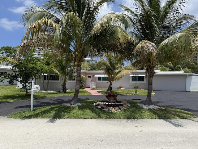 1760 Bel Air Ave, Lauderdale By The Sea, FL 33062 - view of front facade featuring stucco siding, driveway, a front lawn, and a garage