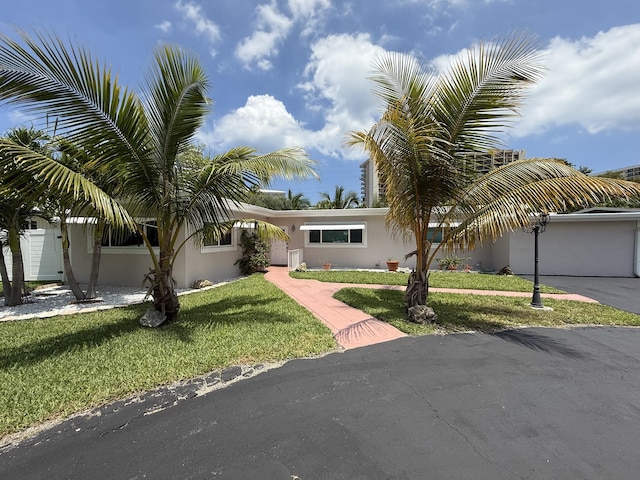 1760 Bel Air Ave, Lauderdale By The Sea, FL 33062 - view of front of home with stucco siding, a front lawn, and driveway