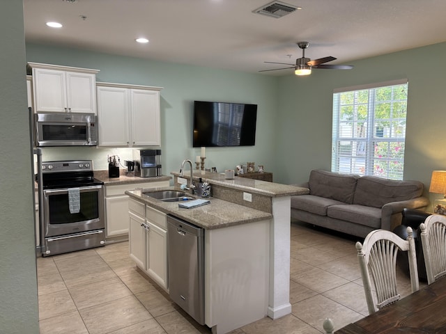 275 SW 7th Ct, Pompano Beach, FL 33060 - kitchen with stainless steel appliances, a sink, open floor plan, white cabinetry, and recessed lighting