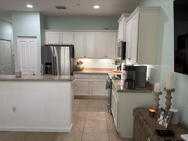 275 SW 7th Ct, Pompano Beach, FL 33060 - kitchen featuring appliances with stainless steel finishes, white cabinetry, recessed lighting, and stone counters