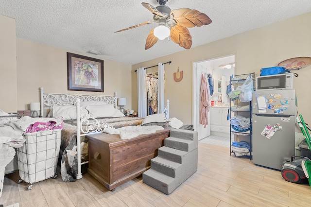 933 S Ridge St, Lake Worth Beach, FL 33460 - bedroom with a textured ceiling, wood finished floors, ceiling fan, and connected bathroom