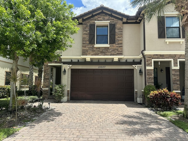 13007 Anthorne Ln, Boynton Beach, FL 33436 - townhome / multi-family property with stone siding, stucco siding, a garage, and decorative driveway