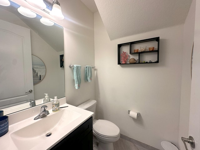 13007 Anthorne Ln, Boynton Beach, FL 33436 - bathroom featuring toilet, vanity, lofted ceiling, baseboards, and a textured ceiling