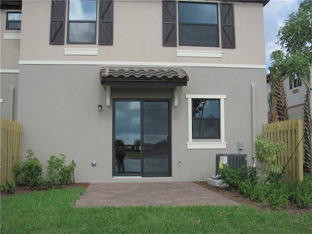 13007 Anthorne Ln, Boynton Beach, FL 33436 - back of house with stucco siding, a patio, and central AC unit