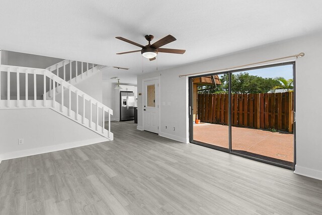 1402 Nebraska Ave Unit 3B, Fort Pierce, FL 34950 - unfurnished living room with wood finished floors, stairway, ceiling fan, and baseboards