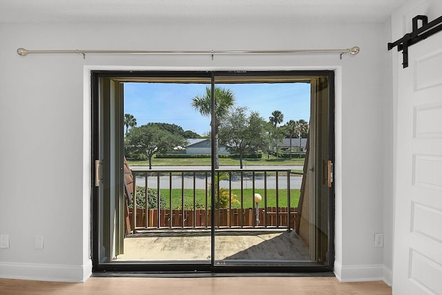 1402 Nebraska Ave Unit 3B, Fort Pierce, FL 34950 - doorway with baseboards, a barn door, wood finished floors, and healthy amount of natural light
