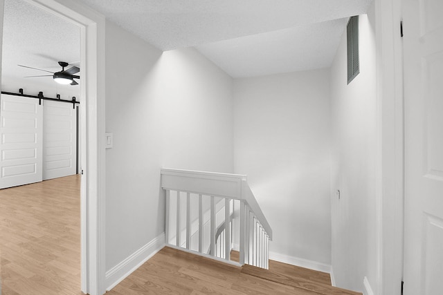1402 Nebraska Ave Unit 3B, Fort Pierce, FL 34950 - additional living space featuring wood finished floors, a barn door, a ceiling fan, baseboards, and a textured ceiling