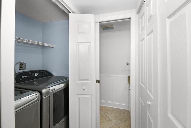 1402 Nebraska Ave Unit 3B, Fort Pierce, FL 34950 - laundry room featuring washer and clothes dryer, a wainscoted wall, and light tile patterned floors