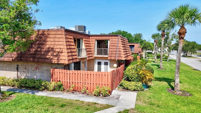 1402 Nebraska Ave Unit 3B, Fort Pierce, FL 34950 - view of side of property with mansard roof, cooling unit, a balcony, and brick siding