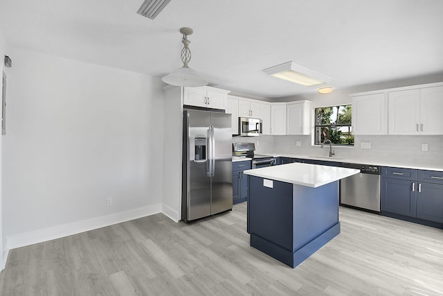 1402 Nebraska Ave Unit 3B, Fort Pierce, FL 34950 - kitchen with stainless steel appliances, white cabinets, light wood finished floors, and light countertops