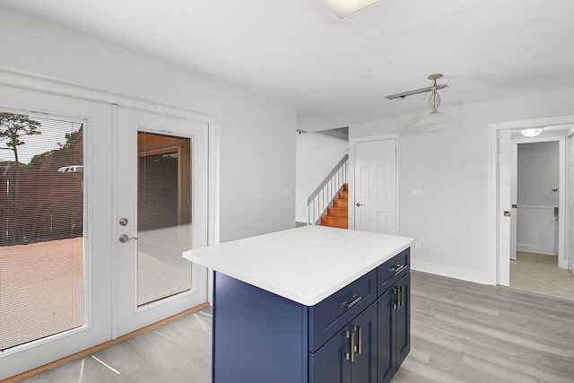 1402 Nebraska Ave Unit 3B, Fort Pierce, FL 34950 - kitchen featuring blue cabinets, light countertops, light wood-style flooring, and a center island