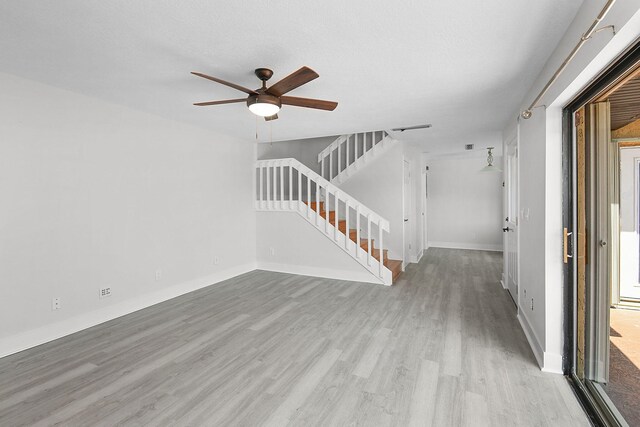 1402 Nebraska Ave Unit 3B, Fort Pierce, FL 34950 - unfurnished living room featuring stairs, light wood finished floors, ceiling fan, and baseboards