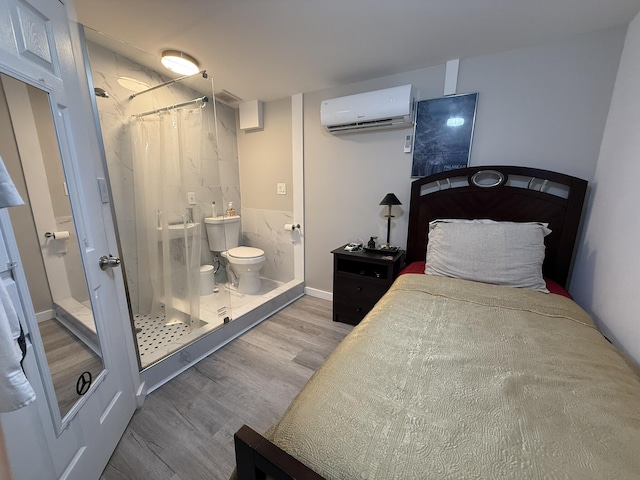 181 Morgans Way, Palm Springs, FL 33461 - bedroom with a wall mounted air conditioner, wood finished floors, and ensuite bathroom