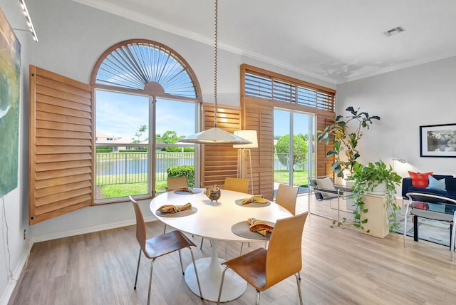 106 Sedona Way, Palm Beach Gardens, FL 33418 - dining space featuring crown molding, wood finished floors, a water view, and baseboards