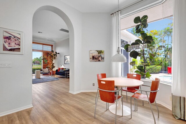 106 Sedona Way, Palm Beach Gardens, FL 33418 - dining space with arched walkways, light wood-type flooring, and baseboards