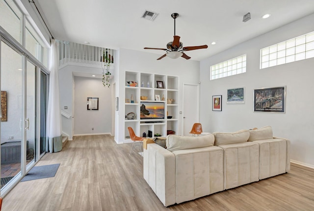 106 Sedona Way, Palm Beach Gardens, FL 33418 - living area featuring light wood-style floors, ceiling fan, baseboards, a towering ceiling, and stairs