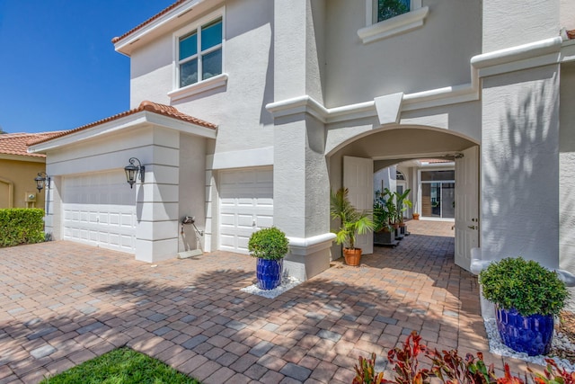 106 Sedona Way, Palm Beach Gardens, FL 33418 - view of front of house with stucco siding, decorative driveway, an attached garage, and a tile roof