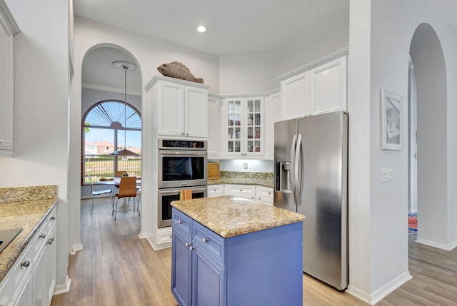 106 Sedona Way, Palm Beach Gardens, FL 33418 - kitchen with appliances with stainless steel finishes, blue cabinetry, arched walkways, white cabinets, and light wood-type flooring