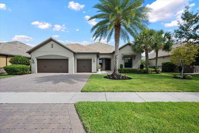 10557 Pisa Rd, Wellington, FL 33414 - single story home with an attached garage, decorative driveway, stucco siding, and a front lawn