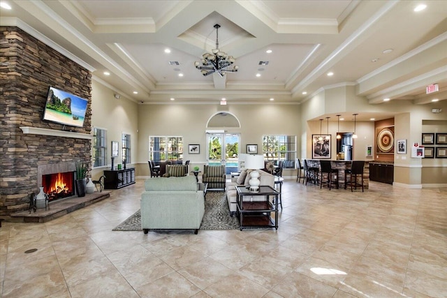 10557 Pisa Rd, Wellington, FL 33414 - living room with a towering ceiling, a stone fireplace, light tile patterned flooring, crown molding, and a chandelier