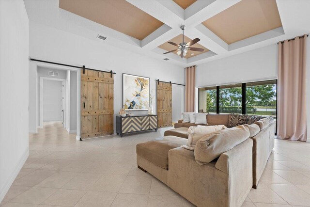 10557 Pisa Rd, Wellington, FL 33414 - living room featuring a barn door, a high ceiling, ceiling fan, coffered ceiling, and baseboards