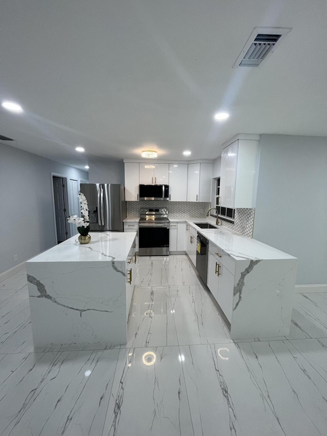 1720 SW 13th St, Boca Raton, FL 33486 - kitchen with appliances with stainless steel finishes, tasteful backsplash, recessed lighting, light stone counters, and a center island