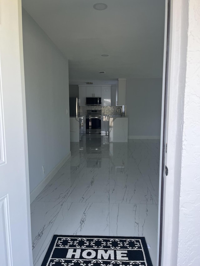 1720 SW 13th St, Boca Raton, FL 33486 - hallway featuring marble finish floors, baseboards, and a sink