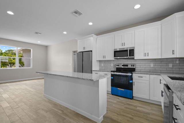 3269 NW 24th Ave, Okeechobee, FL 34972 - kitchen featuring stainless steel appliances, recessed lighting, a kitchen island, tasteful backsplash, and white cabinetry