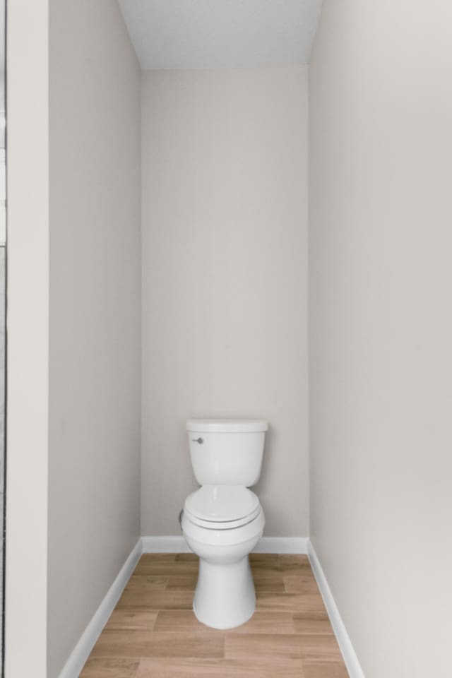 3269 NW 24th Ave, Okeechobee, FL 34972 - bathroom featuring toilet, wood finished floors, and baseboards