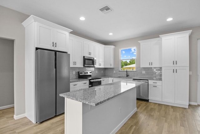 3269 NW 24th Ave, Okeechobee, FL 34972 - kitchen with appliances with stainless steel finishes, a sink, a kitchen island, decorative backsplash, and recessed lighting