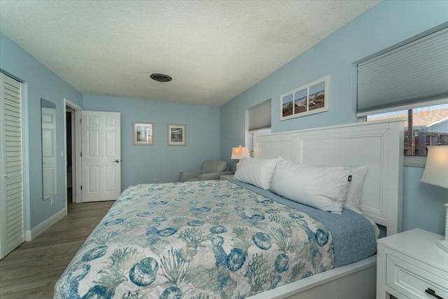 71 S Las Olas Dr, Jensen Beach, FL 34957 - bedroom featuring wood finished floors, a textured ceiling, and baseboards