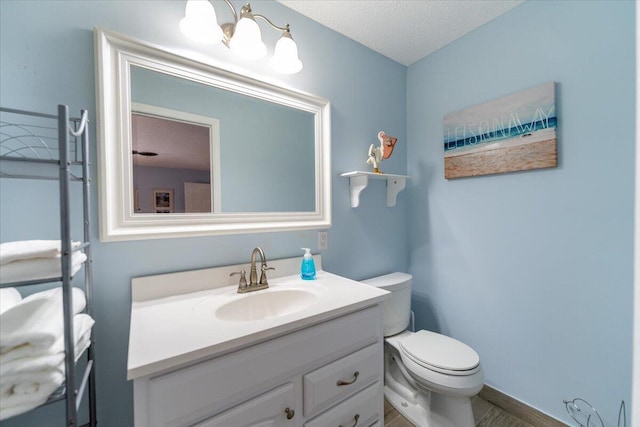 71 S Las Olas Dr, Jensen Beach, FL 34957 - half bathroom featuring toilet, vanity, and a textured ceiling