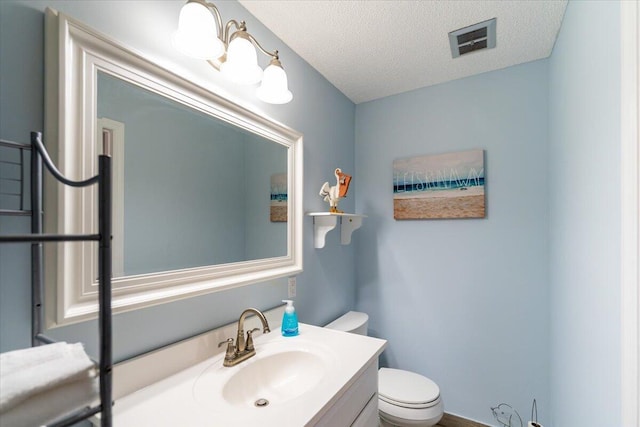 71 S Las Olas Dr, Jensen Beach, FL 34957 - bathroom with toilet, vanity, and a textured ceiling