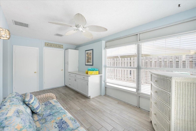 71 S Las Olas Dr, Jensen Beach, FL 34957 - bedroom with light wood finished floors, a textured ceiling, and a ceiling fan