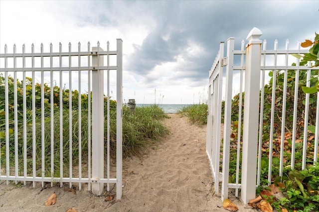 71 S Las Olas Dr, Jensen Beach, FL 34957 - gate featuring fence and view of water and beach