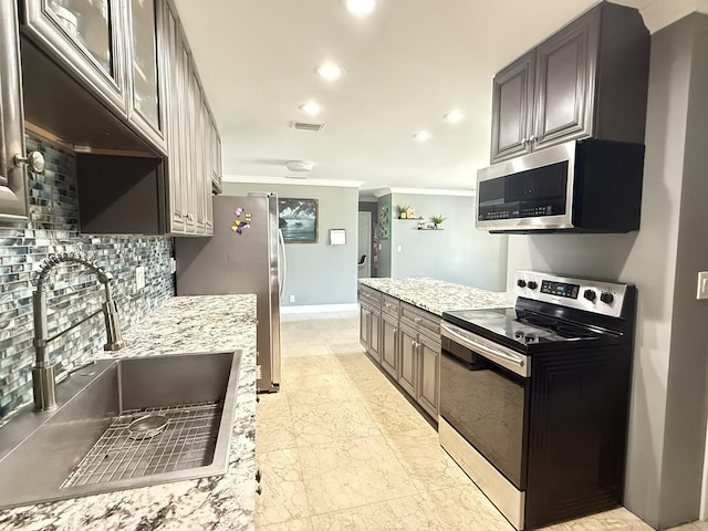 257 SW 5th St, Boca Raton, FL 33432 - kitchen with appliances with stainless steel finishes, a sink, ornamental molding, tasteful backsplash, and recessed lighting