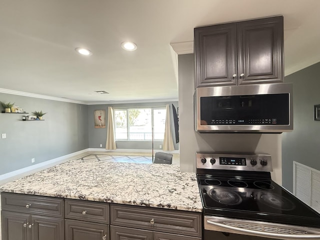257 SW 5th St, Boca Raton, FL 33432 - kitchen featuring stainless steel appliances, crown molding, baseboards, dark brown cabinetry, and light stone countertops