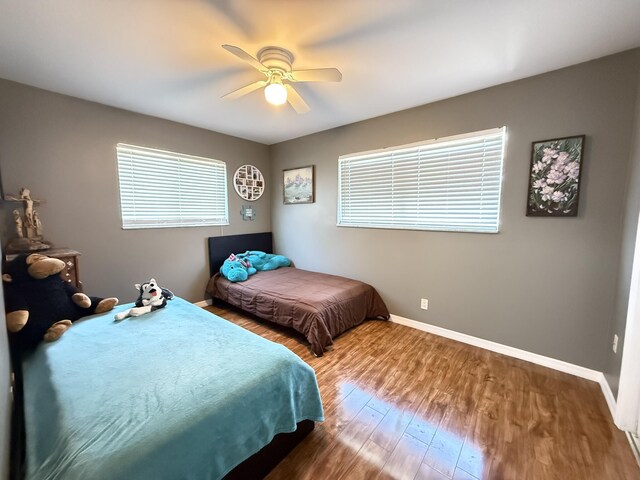 257 SW 5th St, Boca Raton, FL 33432 - bedroom featuring baseboards, wood finished floors, multiple windows, and a ceiling fan